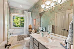 Full bathroom with crown molding, vanity, light tile patterned flooring, wallpapered walls, and a chandelier