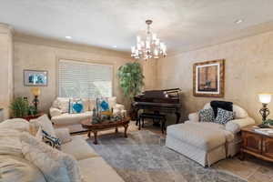 Formal Living room featuring crown molding, a chandelier, a textured ceiling, and recessed lighting