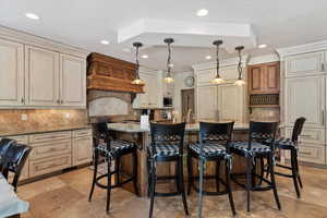 Kitchen featuring cream cabinets, tasteful backsplash, pendant lighting and recessed lighting.