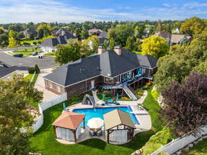 View of pool with a patio, a water slide, a fenced backyard, stairs, and a residential view