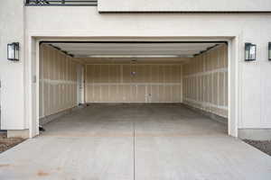 Garage with concrete driveway and a garage door opener