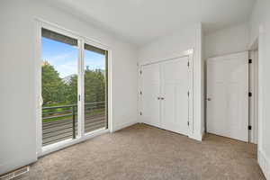Bedroom #2 with carpet, access to outside, and a closet. Juliet balcony.