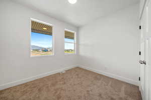 Empty room with carpet, a mountain view, and lofted ceiling