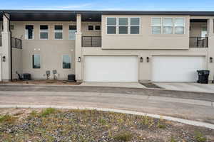 View of front of property with stucco siding, driveway, and an attached garage