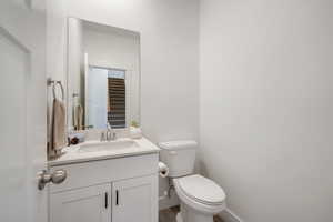 Half bath featuring vanity and wood finished floors