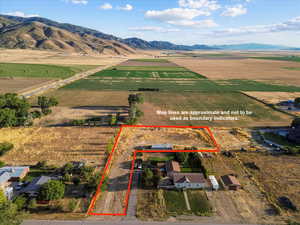 View of rural area with mountains, large plots for crops, and property parcel outlined