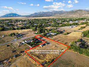 Aerial view of sparsely populated area with a mountainous background and property boundaries highlighted