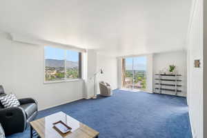 Carpeted living room featuring a mountain view and crown molding