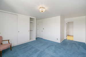 Unfurnished bedroom featuring a closet, carpet flooring, and a chandelier