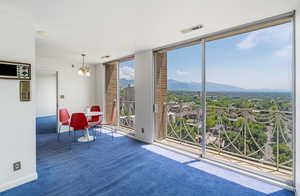 Interior space featuring expansive windows, a mountain view, and a chandelier