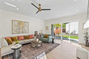Living room with light wood finished floors, recessed lighting, and a ceiling fan
