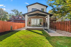 Back of property with a fenced backyard, a patio area, and board and batten siding
