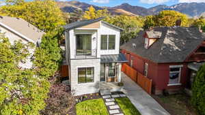 View of front facade with a mountain view, stone siding, a metal roof, a standing seam roof, and board and batten siding