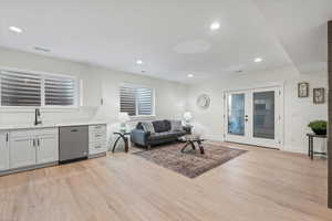 Living area with french doors, recessed lighting, light wood-type flooring, and healthy amount of natural light