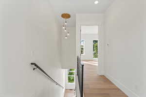 Stairs featuring wood finished floors and recessed lighting