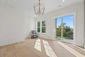 Unfurnished room featuring light wood finished floors, recessed lighting, and a chandelier