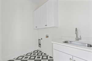 Washroom featuring cabinet space, hookup for a washing machine, and electric dryer hookup
