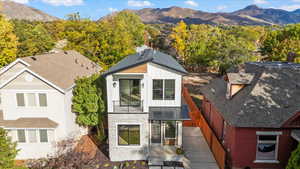 Rear view of property with a mountain view, board and batten siding, stone siding, a standing seam roof, and a metal roof