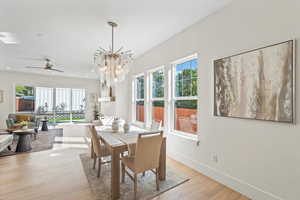 Dining space with a chandelier, light wood-type flooring, and ceiling fan