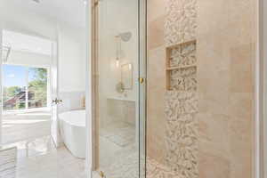 Bathroom featuring a shower stall, a soaking tub, and tile walls