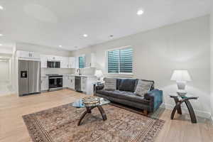 Living room with light wood finished floors and recessed lighting