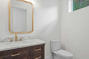 Half bathroom featuring vanity and toilet