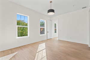 Spare room featuring light wood-style flooring and baseboards
