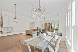 Dining area with recessed lighting, light wood-style floors, and a chandelier