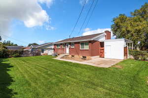 Rear view of property with a chimney and brick siding