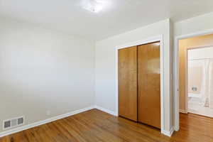 Unfurnished bedroom featuring wood finished floors and a closet