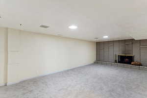 Unfurnished living room with light carpet and a fireplace