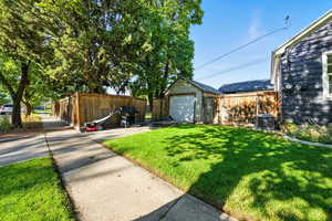 View of yard with an outdoor structure, a garage, and driveway