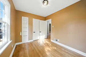 Unfurnished bedroom with wood finished floors and baseboards