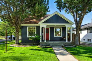 Bungalow-style home featuring a porch and a front lawn