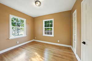 Empty room featuring baseboards and light wood-style flooring
