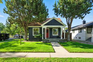 View of front of property featuring covered porch and a front yard