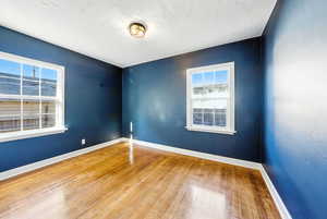 Unfurnished room featuring wood finished floors and a textured ceiling