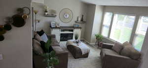 Living room featuring a glass covered fireplace, wood finished floors, and a textured ceiling
