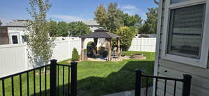 Fenced backyard with a patio area, a gazebo, and a fire pit