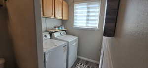 Laundry room featuring washer and clothes dryer, dark wood-style flooring, and cabinet space