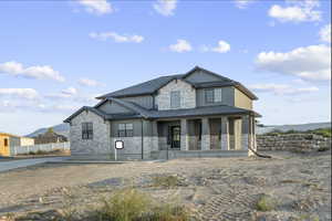 Craftsman inspired home featuring a standing seam roof, a metal roof, and covered porch