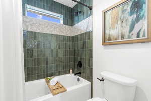 Full bathroom with shower / bath combination with curtain and toilet