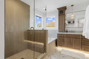 Full bath with a garden tub, vanity, a shower stall, and light marble finish floors