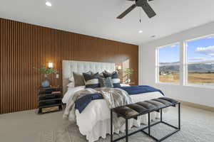 Bedroom featuring carpet floors, wood walls, a mountain view, a ceiling fan, and recessed lighting