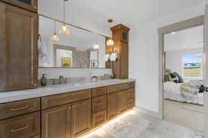 Bathroom with double vanity, ensuite bath, and light marble finish floors