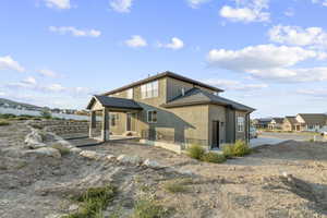 Rear view of house with a patio area and stucco siding