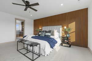 Carpeted bedroom with wood walls, ceiling fan, recessed lighting, an accent wall, and connected bathroom
