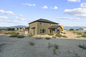 View of front of home with a mountain view, a patio area, and stucco siding