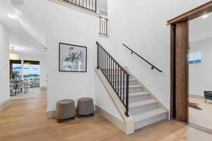 Stairway featuring healthy amount of natural light, wood finished floors, recessed lighting, and a towering ceiling