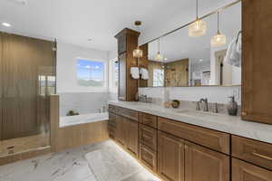 Full bathroom with a garden tub, a stall shower, double vanity, light marble finish floors, and recessed lighting